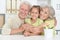 Portrait of grandparents with granddaughter posing at home