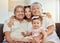 Portrait, grandparents hug and family with children and happiness on a living room . Fun, baby smile and bonding with