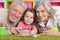 Portrait of grandparents playing with their grandaughter while lying on floor