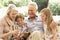 Portrait Of Grandparents Reading To Grandchildren On Sofa