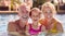 Portrait Of Grandparents Teaching Granddaughter To Swim On Family Summer Holiday In Pool 