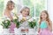 Portrait of granny with granddaughters watering flowers