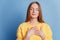 Portrait of grateful sincere lady close eyes hands chest heart form on blue background