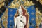 Portrait of the Great Standing Buddha statue against the colorful wall of Wat Rong Suea Ten or Blue Temple, Chiang Rai