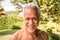 Portrait of grizzled smiling senior man in the garden on a sunny day.