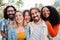 Portrait of a group of friends laughing together and looking at camera. Five young multiracial cherful people smiling