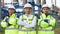 Portrait of group of professional electric industry engineers smiles and looks at the camera . Workers wearing safety