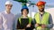 Portrait of a group of specialists in a construction site looking straight to the camera and smiling large they looking
