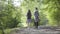 Portrait of guy and young cute girl walking in the forest. Pair of travelers with backpacks outdoors. Leisure couples