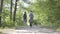 Portrait guy and young cute girl walking in the forest. Pair of travellers with backpacks outdoors. Leisure couples