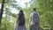 Portrait of guy and young girlfriend walking in the forest. Pair of travellers with backpacks outdoors. Leisure couples
