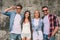 Portrait of guys and girls posing on camera. Young men wears glasses. Three of them are looking on camera and smiling