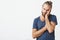 Portrait of hadsome young man with stylish hairstyle and beard in blue t-shirt beig tired after spending day with little