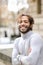 Portrait of half african smiling boy wearing grey turtleneck sweater and having curly brown hair.