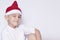 Portrait of handsome 6-7 year old middle-eastern child in Santa hat. Little cute kid smiling and winking. Celebrating Christmas