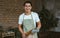 Portrait handsome adult Asian man wearing eyeglasses, apron, holding rolling pin for cooking in kitchen at home during holiday,