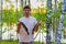 Portrait of handsome adult man holding raw caught pike fish in hands. Happy fisher standing with fish against beautiful summer