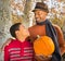 Portrait of Handsome African-American father and happy son choosing a pumpkin in Autumn.