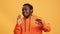 Portrait handsome African American young man dancing singing song good vibes posing isolated orange