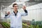 Portrait of handsome agricultural researcher working on research at plantation in industrial greenhouse