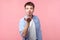 Portrait of handsome amorous brown-haired man sending air kiss, flirting. indoor studio shot isolated on pink background