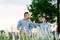 Portrait of a handsome Asian couple in the same color scheme jokingly posing for a photo together in a grass field at sunset in a