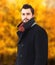 Portrait handsome bearded brunette man wearing a black coat in autumn day