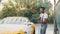 Portrait of handsome bearded young African man washing his yellow car with foam at at self service car wash outdoors