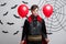 Portrait of handsome caucasian in Vampire halloween costume with colorful Balloon.