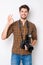 Portrait of handsome cheerful photographer with camera gesturing ok