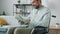 Portrait of handsome disabled man reading book sitting in wheelchair at home