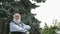 Portrait of handsome gray-haired senior man at tree background