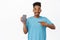 Portrait of handsome happy african american man pointing finger at mobile phone, smiling pleased, showing smartphone