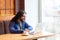 Portrait of handsome happy bearded young adult man freelancer in casual style sitting in cafe and chating with his friend in