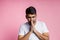 Portrait of handsome Indian guy standing on pink background