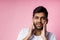 Portrait of handsome Indian guy standing on pink background