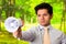 Portrait of a handsome mad man holding in his hand a megaphone, in a blurred green background