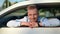 Portrait of handsome male businessman posing at white luxury sport car looking through open window