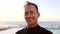 Portrait of a handsome male surfer in a wetsuit by the beach. Mature man waiting for the current, tide and waves to surf