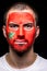 Portrait of handsome man face supporter fan of Morocco national team with painted flag face isolated on black background. Fans emo