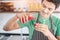 A portrait of handsome man making cold presses fruit juice in a modern kitchen.