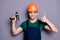 Portrait of handsome man repairer successful handyman hold perforator show thumb up sign wear orange hard hat green t