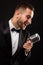 Portrait of handsome man sing on microphone on black background.