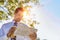 Portrait of handsome mature businessman holding cup of coffee while reading newspaper in park during break