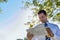 Portrait of handsome mature businessman holding cup of coffee while reading newspaper in park during break