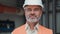 Portrait of handsome mature engineer posing on background of plastic pipes