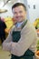 Portrait handsome seller with arms crossed in supermarket