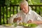 Portrait of handsome senior man eating