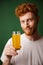 Portrait of handsome smiling bearded man holding glass of orange