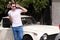 Portrait of a handsome smiling man with sunglasses, male model posing in urban city street next his car.